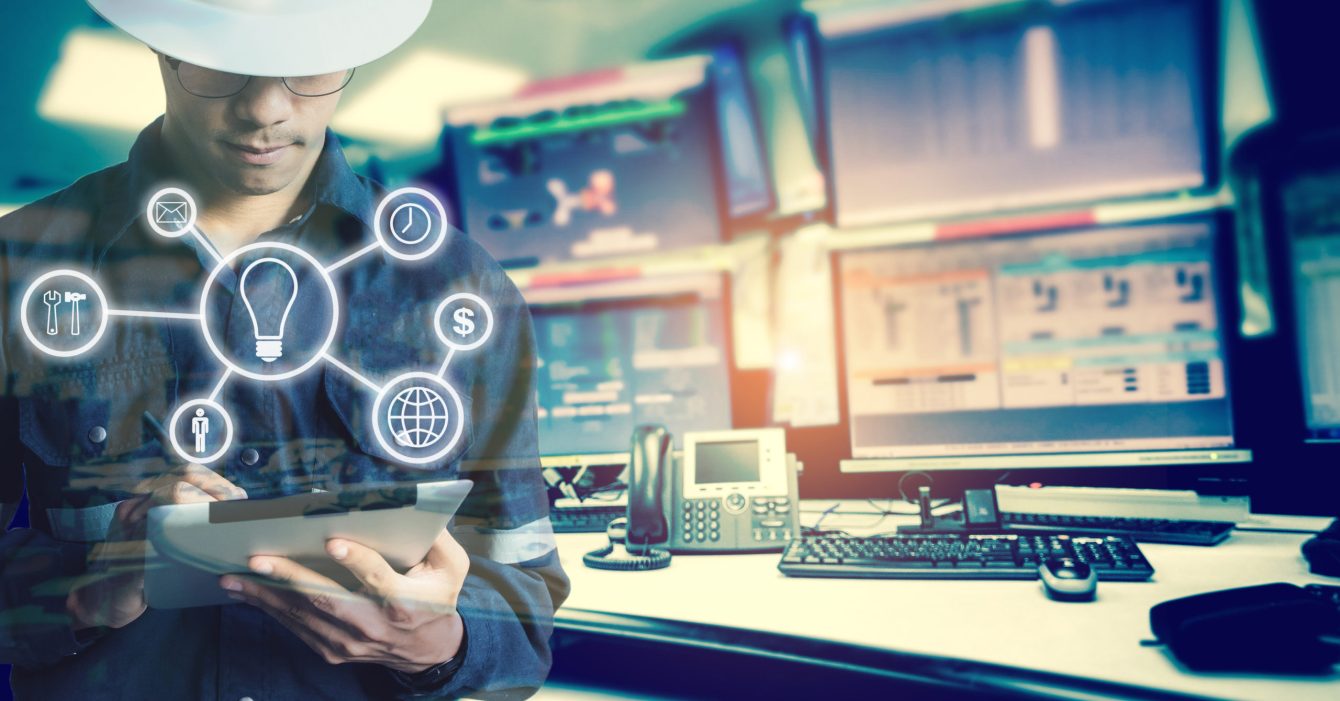 Double exposure of Engineer or Technician man with business industrial tool icons while using tablet with monitor of computers room  for oil and gas industrial business concept