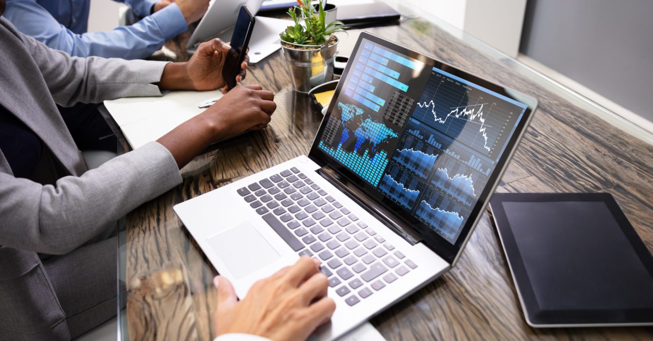 Group Of Businesspeople Examining Graph On Computer